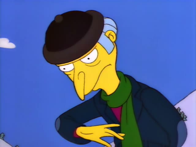Mr. Burns wears a navy coat and green scarf against a bright blue sky with snowy ground at the edges