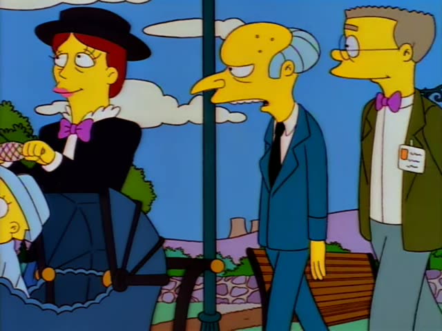 Mr. Burns stands beside a park bench holding a pink-and-yellow kite spool, while a woman in a black hat and dark dress…