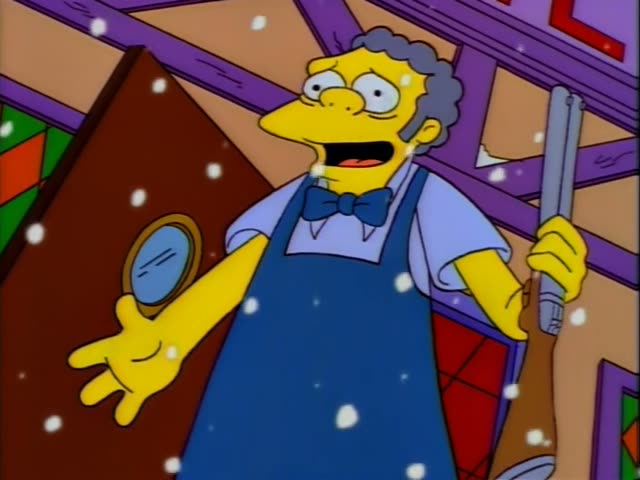 Moe stands in a wood-beamed room with stained-glass windows while snow falls around him
