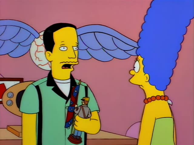 A thin, moustached man in a green shirt with a black collar and suspenders, and Marge Simpson with her tall blue beehive…