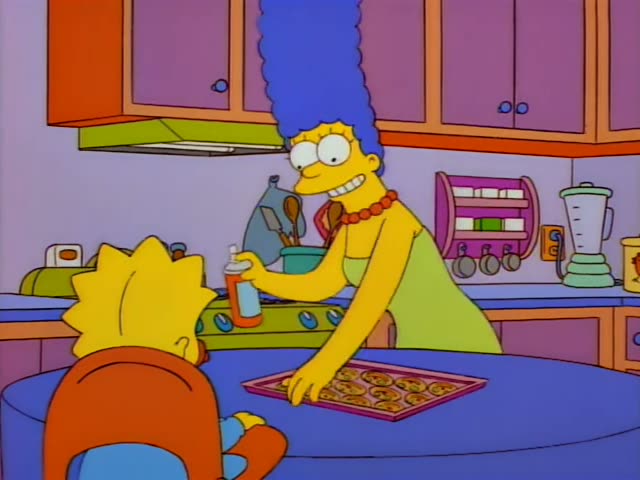 Marge Simpson stands at the kitchen counter spraying a tray of cookies with an orange spray bottle while Bart watches…