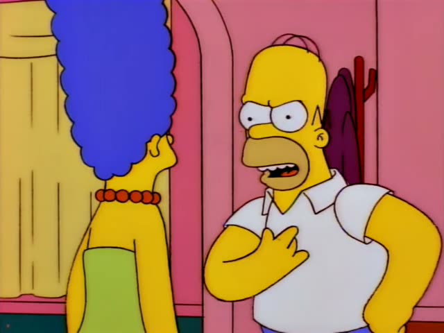 Homer and Marge Simpson stand in a pink hallway beside a yellow wall, Homer glaring and gesturing at his chest while Marge…
