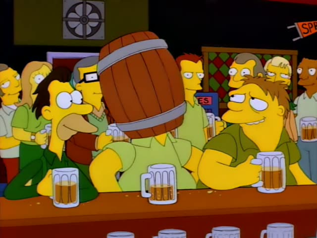 Homer sits at the bar of Moe's tavern with Barney, Carl, and a long-nosed man in green, all holding beer mugs, while a crowd…