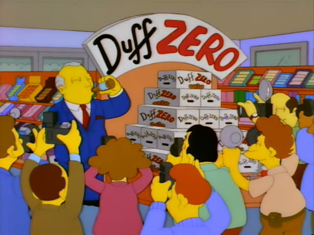 An older grey-haired man in a blue suit and red tie, surrounded by a crowd of onlookers in a store with raised hands, lifts…