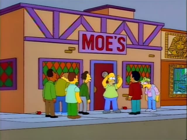 Homer stands outside the entrance of Moe's with a group of men on the sidewalk, including a bespectacled man in a green cap…