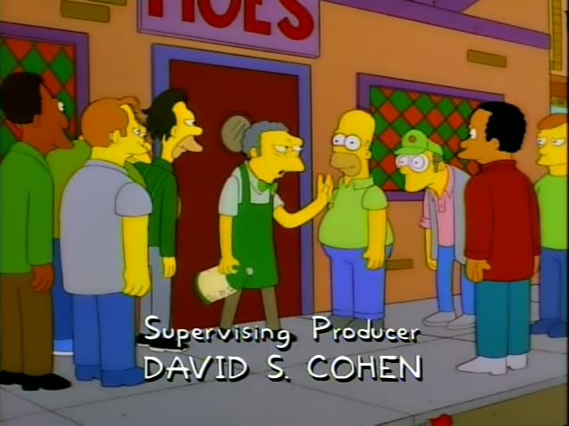 Moe stands at the red door of his tavern, labeled MOES, as a line of men on the sidewalk gathers, including Homer in a green…