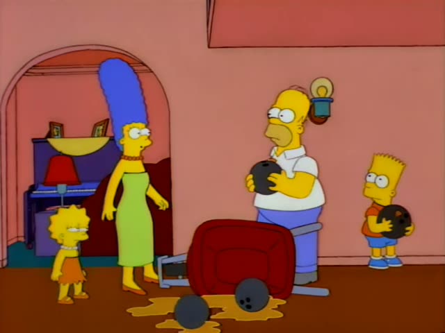 Homer stands holding a bowling ball in a pink living room while Marge, with her tall blue beehive and green dress, Lisa…