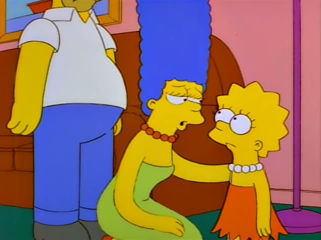 Marge with her tall blue beehive and red beads and Lisa in her red dress and pearl necklace first stand in a living room…