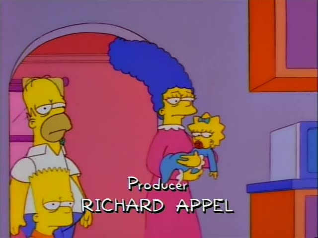 Homer, Marge holding baby Maggie, and Bart stand together in a pink arched doorway, with Homer and Bart looking unimpressed…