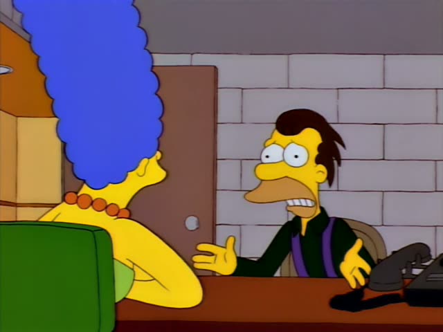 Marge sits at a desk facing a man with swept-back brown hair, a dark green shirt and purple suspenders