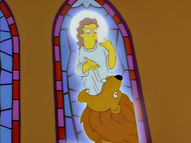 A stained-glass figure with a halo, in a white robe, gestures beside a golden lion in an arched church window…