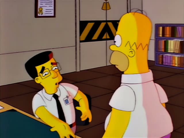 Homer stands facing Smithers, a thin man with glasses, black hair, a white shirt, black tie and ID badge, who sits at a desk…