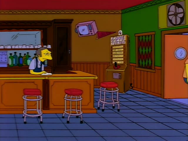Moe stands behind the orange wooden bar of his tavern, wiping it with a white rag