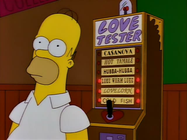 Homer Simpson stands beside a Love Tester machine in a dim bar with wood-panel walls and a green wall at right