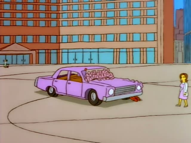 Homer Simpson stands at a blue public payphone on a plaza in front of a tall brick office building, holding the receiver…