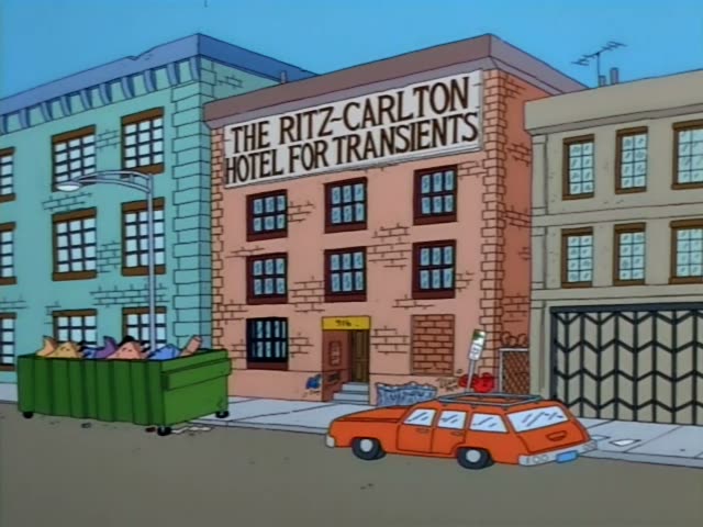 Outside the Ritz-Carlton Hotel for Transients, a brick building with a sign on its facade, a green dumpster holds several…