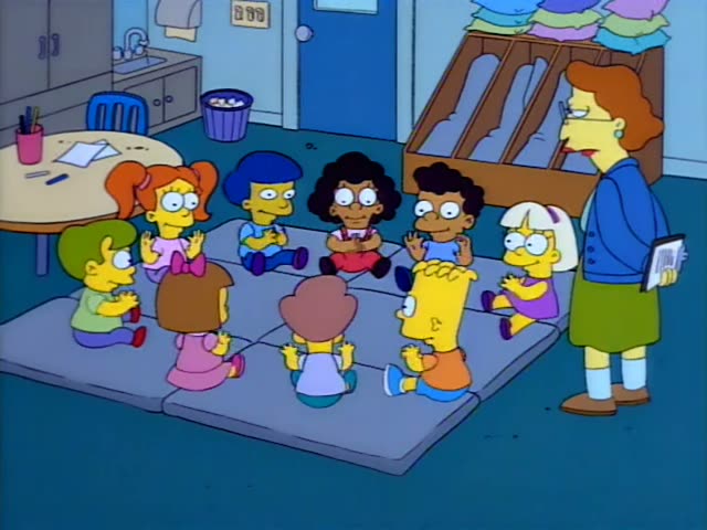 Bart Simpson first sits anxiously in a purple bus seat, then joins a circle of young children on blue mats in a classroom…