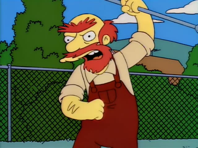 Bart walks along a path past a chain-link fence where a stocky, angry red-bearded man in red overalls shouts and waves…