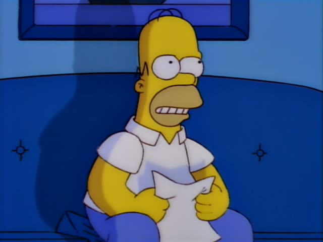 Homer Simpson sits on a blue couch reading a sheet of paper with a shocked, open-mouthed expression, then gestures…