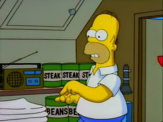 Homer stands in a fallout shelter stocked with green cans labeled STEAK and BEANS, a boombox, folded blankets…