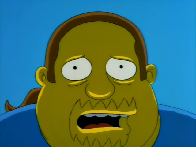 A heavyset, unnamed cartoon man with a bald brown-haired crown, a scraggly beard and a blue shirt fills the close-up…