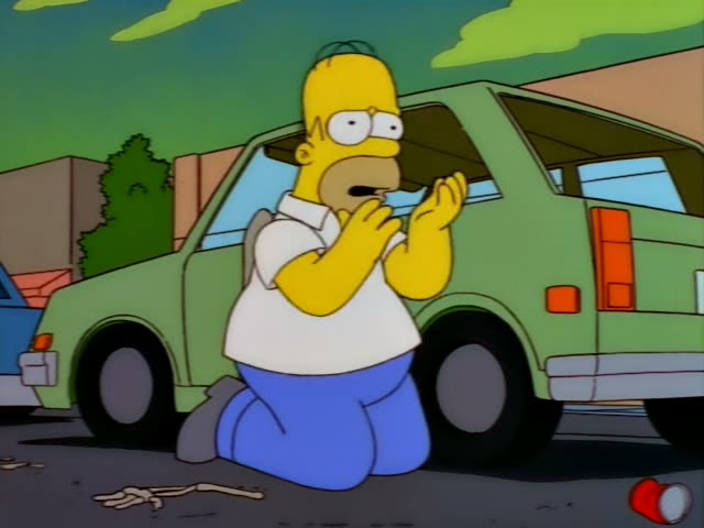 Homer Simpson kneels on the pavement beside a green minivan in a suburban street, first covering his face with both hands…
