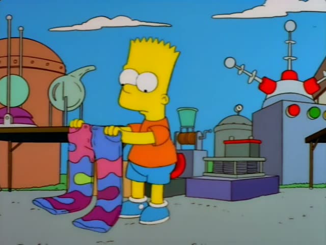 Bart holds a pair of striped mood socks at a sunny outdoor junk stall, then lifts them up and dangles them while he talks
