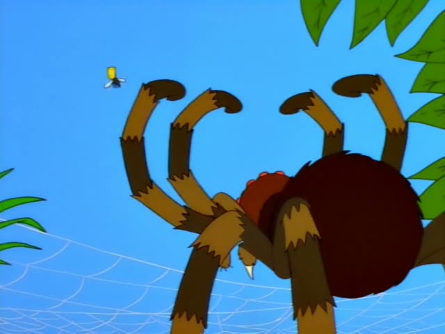 Homer and Marge sit on a brown couch in the living room, with a small boy in an orange shirt and spiky hair holding a pink…
