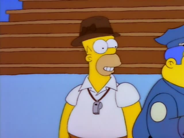Homer and Chief Wiggum stand together by a wooden-slatted wall before Homer walks to a bench and sits down, setting his hat…