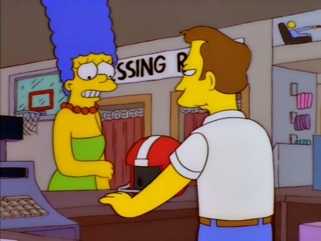 Marge Simpson stands at a store counter beside a sign reading "Dressing Rooms," while a brown-haired clerk in a white polo…