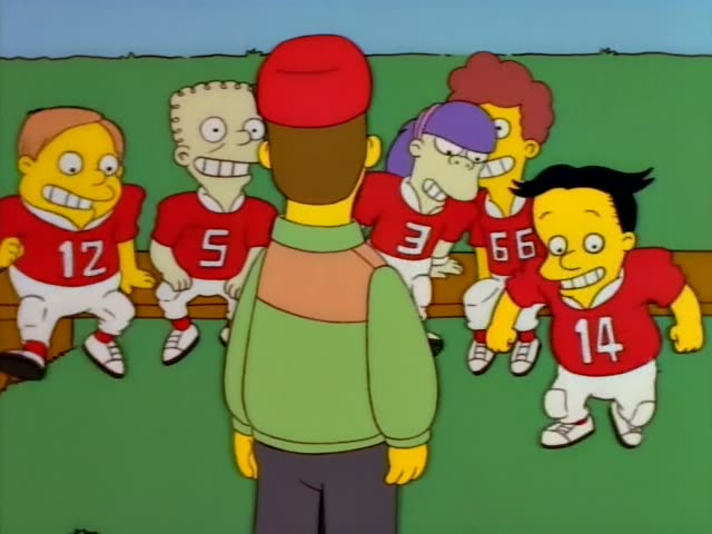 Ned Flanders stands before a wooden bench where players in red football jerseys numbered 12, 5, 3, 66 and 14 sit and watch…