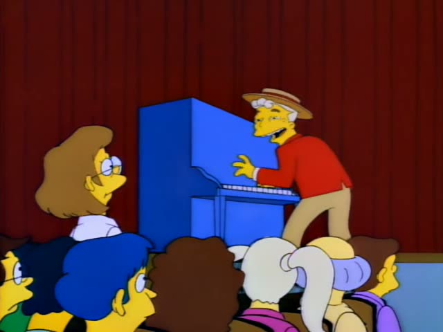 Grampa plays a blue upright piano on a stage with red curtains while Apu grins from the right and Mrs. Krabappel watches…