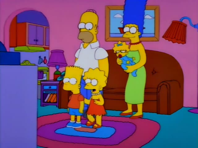 Bart and Lisa stand in the living room in front of a brown couch, with Homer's legs and white shirt looming behind them