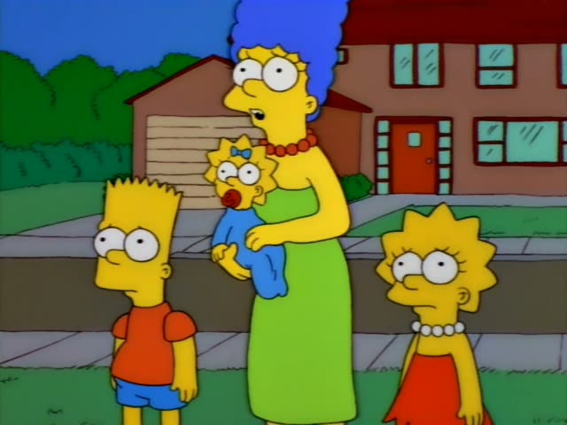 Marge stands on the sidewalk holding Maggie, a baby with a pacifier and blue bow, while Bart and Lisa stand…
