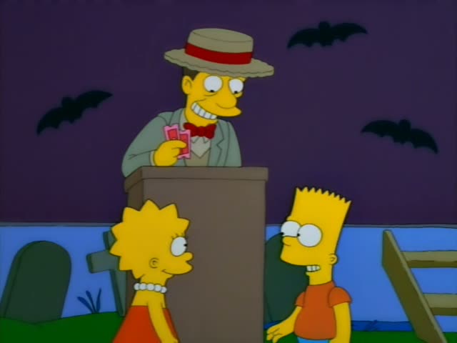Lisa and Bart stand before a grinning man in a straw boater with a red band, a grey jacket and a red bow tie, who holds…