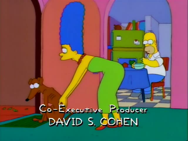 Marge Simpson leans forward with one hand on Santa's Little Helper, the brown greyhound sitting on a green mat by a pink…