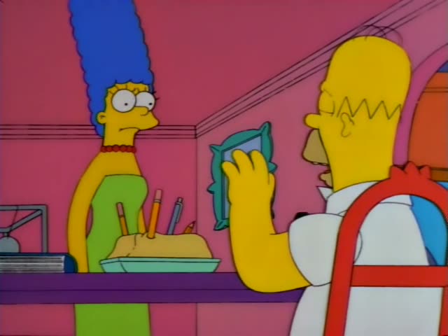 Homer stands at a purple counter in a pink room while Marge looks on