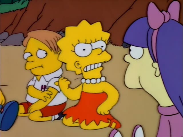 Lisa Simpson sits with her arms crossed on a sandy beach beside a boy with orange hair in a white shirt and red shorts…