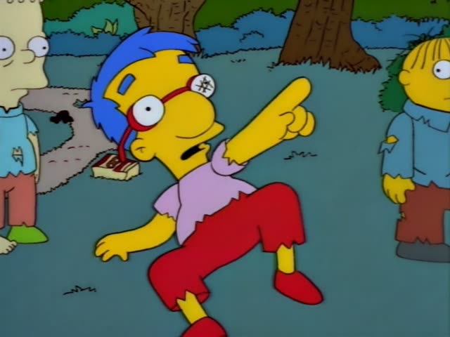 Milhouse is first seen on a grassy park path beside a fallen book, then points and gestures while talking