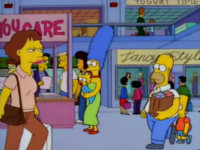 Homer, carrying a brown box, Marge with her tall blue beehive holding baby Maggie, and Lisa and Bart walk past a pink 'LAUGH…