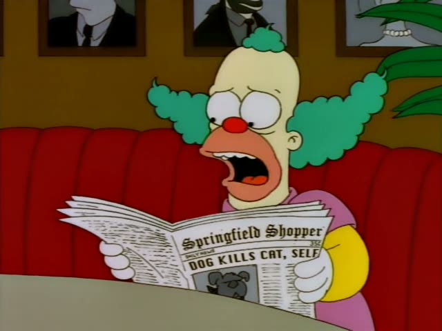 Krusty the Clown sits on a red booth couch in a room with framed portraits and a potted plant, reading the Springfield…