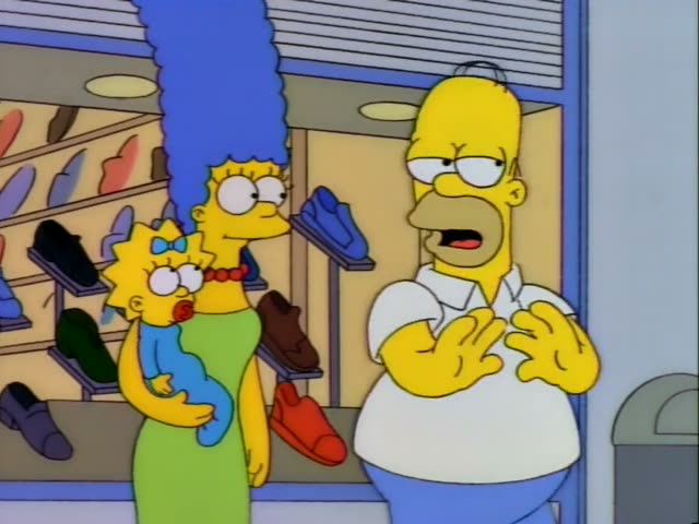 Marge Simpson holds baby Maggie in a shoe store lined with shoe displays while Homer stands beside them at first