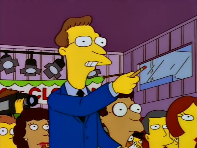 A press conference in a purple-walled room with a red-lettered banner behind the crowd: first a bespectacled reporter…