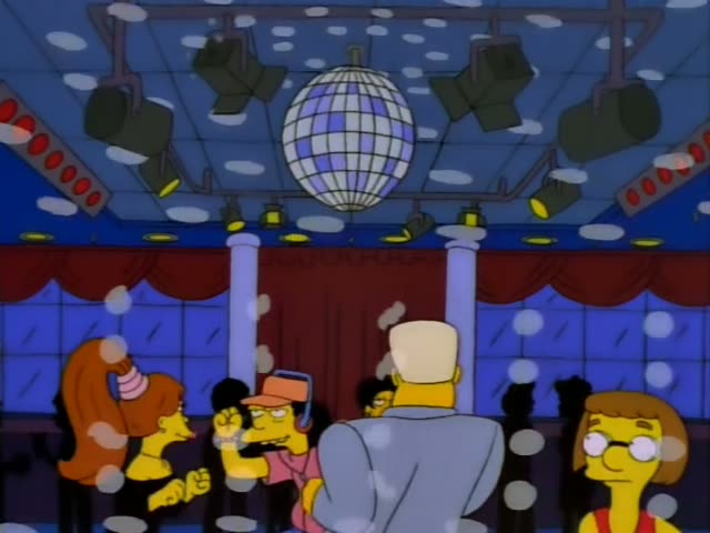 A lively party on a checkered dance floor under a mirrored disco ball has Sideshow Bob, with his huge spiky red mane…