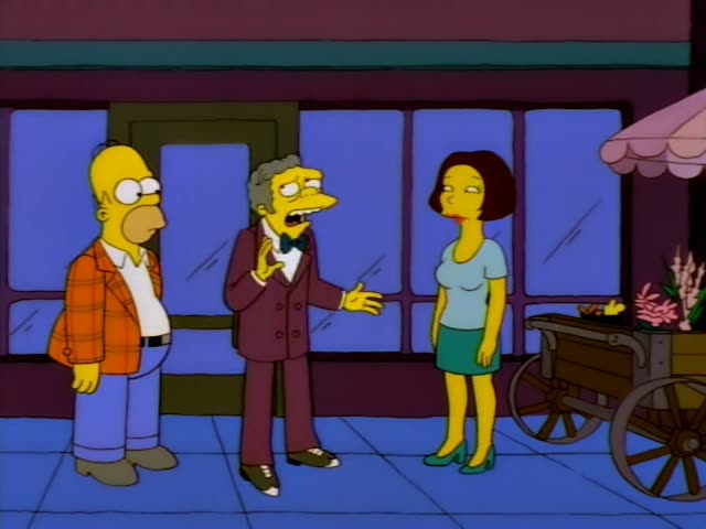 Homer Simpson stands on a city sidewalk beside Mr. Burns, the stooped old man with grey hair at the sides and a maroon suit…