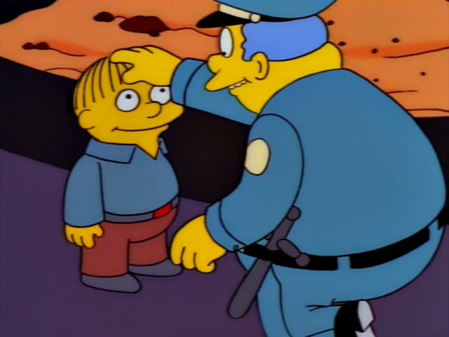 Chief Wiggum first hugs a small blond boy in a blue shirt and red pants, then pats his head while the boy grins and stands…