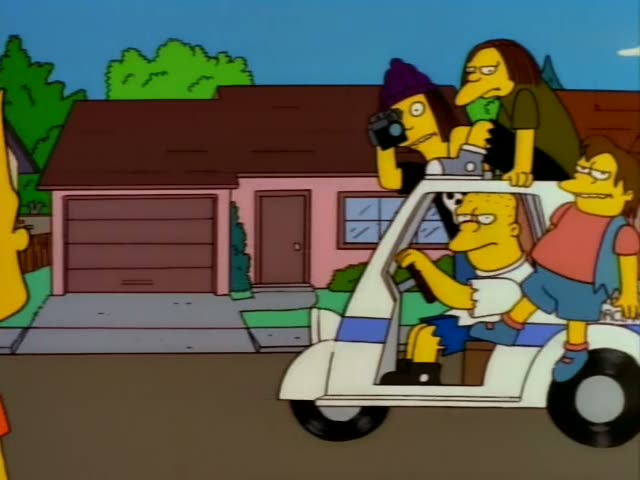 Homer drives a white cart marked PARKING ENFORCEMENT down a suburban street while a purple-haired woman films…