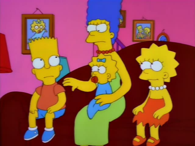 Bart, Marge, Maggie and Lisa are on a dark red couch in a pink living room, with framed pictures of Maggie and Bart…