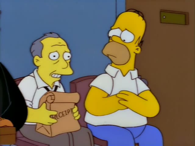 Homer sits on a maroon couch in a plain room beside an unnamed balding, grey-haired man in a white shirt and suspenders…