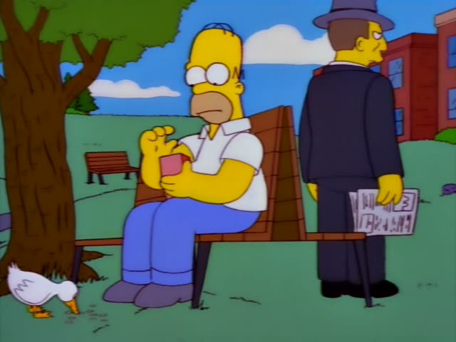Homer Simpson sits on a park bench under a tree, holding a pink cup, while a man in a grey fedora and dark suit…